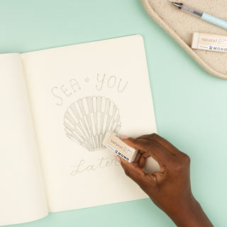 Hand using Tombow MONO natural eraser to erase a seashell outline