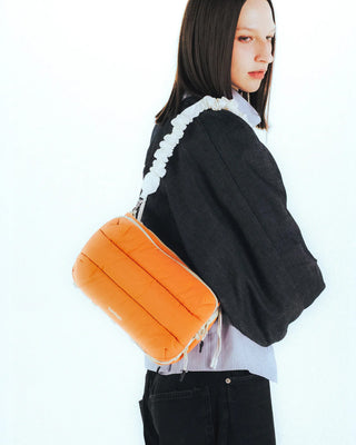 Ecru ruched bungee shoulder strap worn sideways with ruffled edge detail