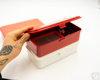 Orange-red stackable tool box with lid open, showing inner compartment