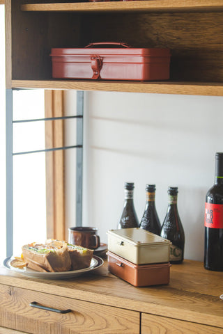 Cream and orange stackable storage box on a wooden shelf