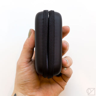 Black mini stationery kit case with zip closure, side view in hand