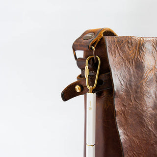 Portable ballpoint pen in a brown leather keyring holder with gold hardware