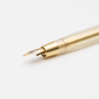 Gold brass dip pen nib detail with engraved pattern near the tip