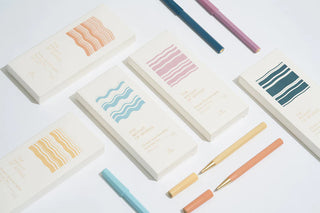 Ocean-toned rollerball pen assortment with gold tips in teal, pink, and orange