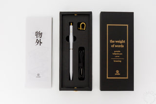 White portable ballpoint pen in a black presentation box with accessories