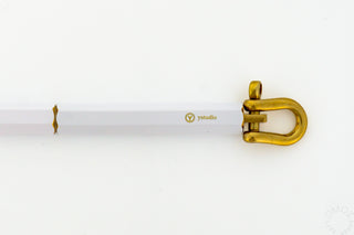 Gold keyring loop attached to a white ballpoint pen