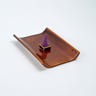 Brown incense burner tray with upright holder and purple incense cone