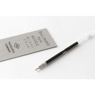 Ballpoint pen refill with black barrel and metal tip extended