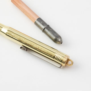 Brass ballpoint pen with engraved branding and exposed roller tip