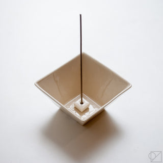 White ceramic incense burner bowl with square base and vertical incense stick