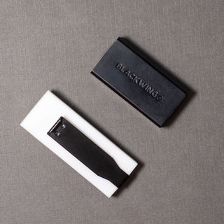 Blackwing eraser and holder pieces in white and dark gray, open compartment