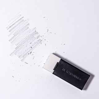 Blackwing handheld eraser and holder with eraser debris on paper