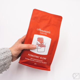 Red Pennsport Blend coffee bag held in hand, with Herman's Coffee logo