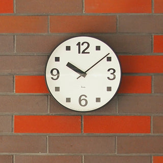 Round wall clock with white face, black numerals, and black hour and minute hands