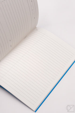 Open A5 lined notebook with cream pages and blue edge binding.
