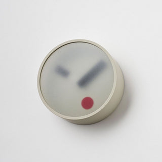 Round wall clock with light grey bezel, minimalist hands, red center dot