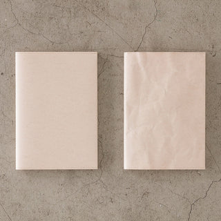 Set of beige notebook paper covers, flat with stitched edges on concrete background