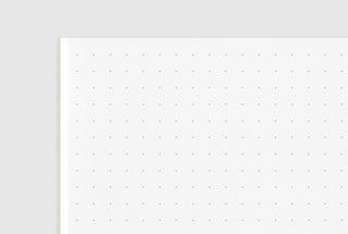 White page with fine dot grid layout, passport-size notebook