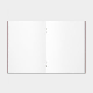 Opened passport-size notebook with blank pages and red edge binding