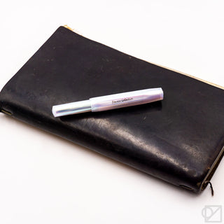 Iridescent pearl fountain pen resting on black leather case