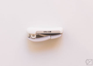 White KOKUYO Karu-Cut tape clip close-up with cutting blade and guide