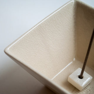 Off-white ceramic incense burner bowl with textured interior and square incense holder