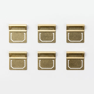 Set of gold-toned brass index clips, nine styles shown front view on white
