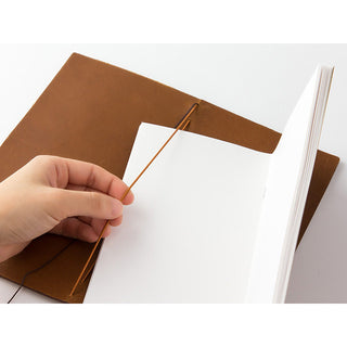 Camel-brown leather notebook with hand lifting cover to insert paper sheets