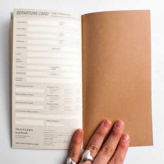 Travel planner notebook with open departure card form and brown folder cover