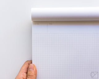 Grid notepad with light gray square grid and header lines on white pages