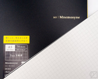 A5 spiral memo notebook close-up: black cover label and white grid paper edge