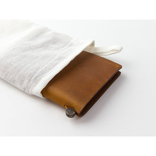 Camel brown leather notebook partly wrapped with white cotton pouch