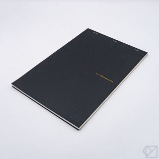 Black hardcover grid notepad with thin gold logo and white page edges
