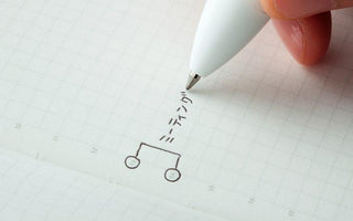 STÁLOGY grid notebook with fine grid page and pen writing