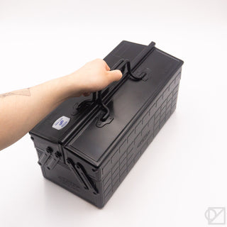 Hand lifting handle on matte black cantilever toolbox, closed
