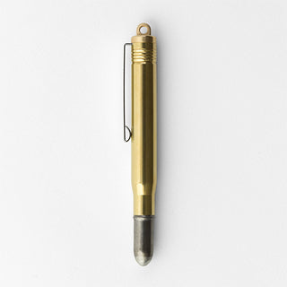 Brass ballpoint pen standing upright with metal loop and gray tip