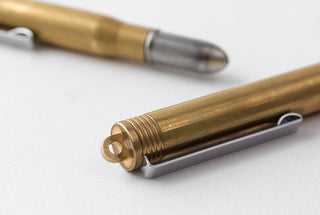Brass ballpoint pen tip and clip end, showing dark insert and metal details