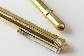 Brass fountain pen tip and nib section close-up, threaded cap detail