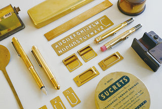 Brass ballpoint pen with parts laid out on a work surface