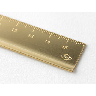 Brass metric ruler close-up: numbers 12–16 and 'TRC' logo