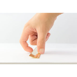 Hand using brass metric ruler
